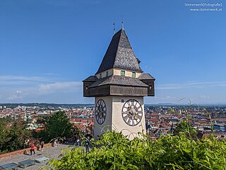 Historischer Uhrturm am Schlossberg mit Blick auf die Stadt Graz bei klarem Himmel